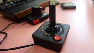 یک جوی استیک Atari 2600+ روی یک میز قرار دارد.